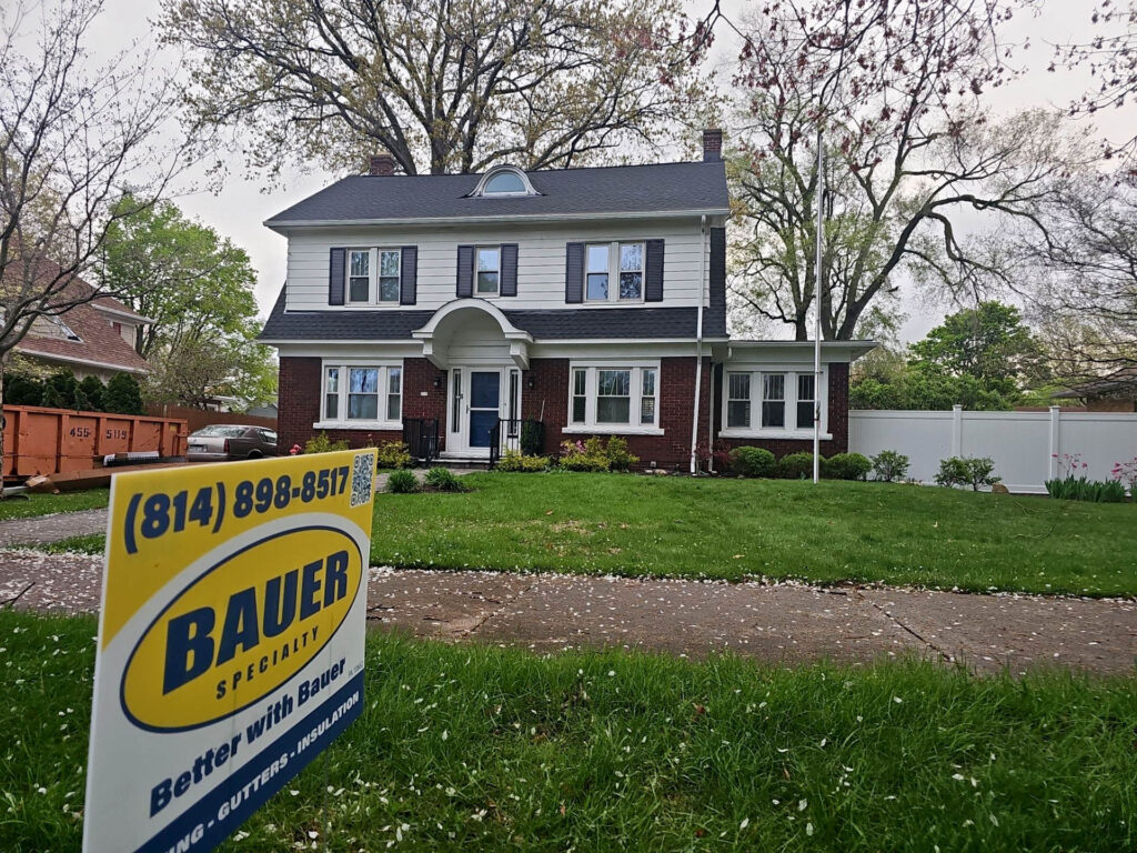 House with new roof with Bauer Specialty Sign in front