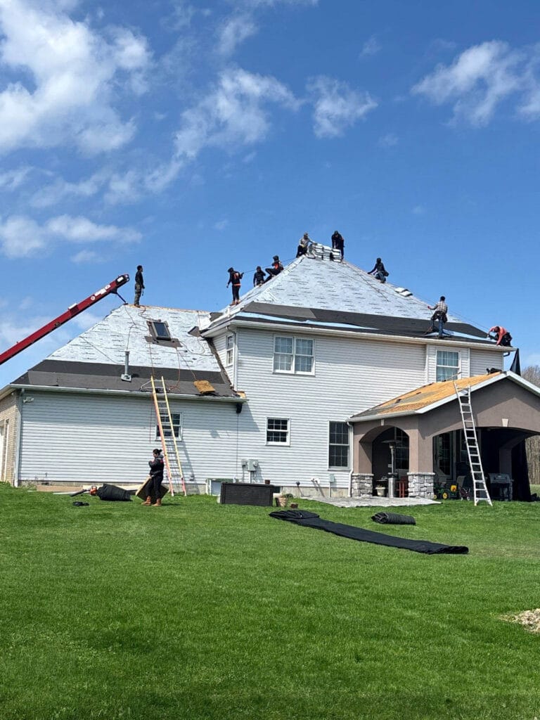 The image shows roofers installing a new roof by Bauer 