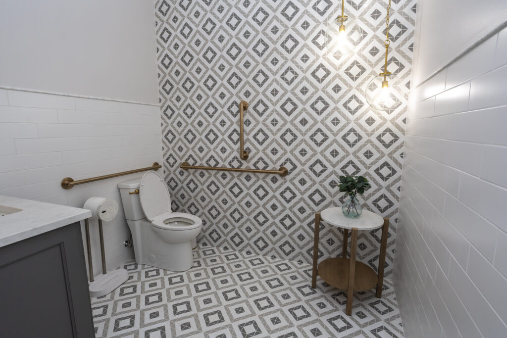 New bathroom with black vanity, white toilet, tiles on wall and new floor