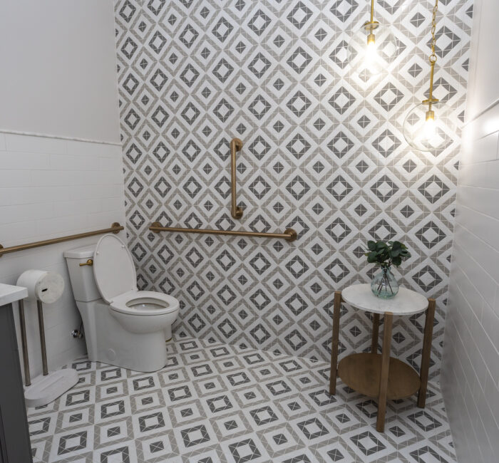 New bathroom with black vanity, white toilet, tiles on wall and new floor
