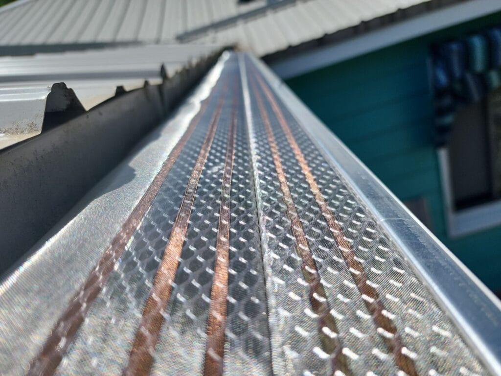 224d4963-e845-4061-92e7-7f707243dd11 The image shows a close up of Klean Gutter covers on a metal roof